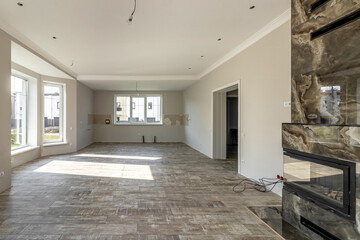 View of the large living room with fireplace immediately after renovation
