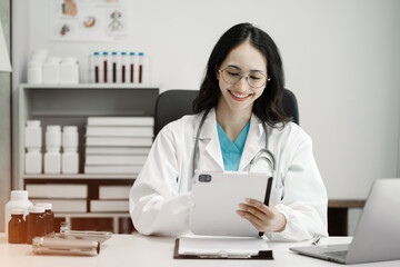 Female doctor working on desk with laptop computer, tablet and paperwork in the office. Medical and doctor concept.