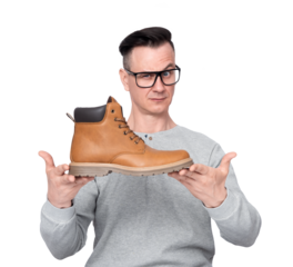 A man in glasses and casual clothes holds a winter boot in his hands, showing it to the camera, isolated on a transparent background png.