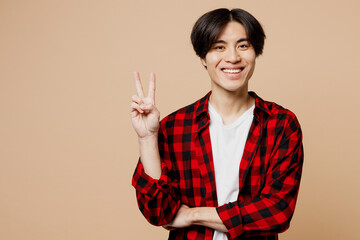 Young smiling happy cheerful man of Asian ethnicity he wear red checkered shirt casual clothes look...