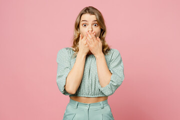 Young shocked scared astonished fearful amazed stupefied woman wear casual clothes look camera cover mouth with hands isolated on plain pastel light pink background studio portrait. Lifestyle concept.