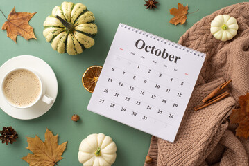 Welcoming autumn spirit. Top view shot featuring calendar with October month, sweater, steaming coffee, raw pattypans, cinnamon sticks, anise and more on green backdrop © ActionGP