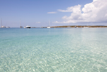 Tranquil beach with sailing boat on clear blue ocean. Formentera Island. Baleares