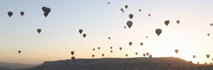 Panoramic view landscape with hot air balloons, sunrise and mountains on background