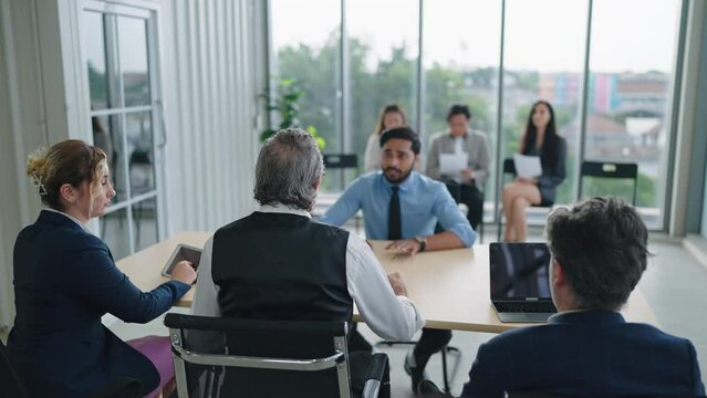 Team of recruiters having interviewing with candidate man employee in conference room. Candidate and interviewer - job interview concept