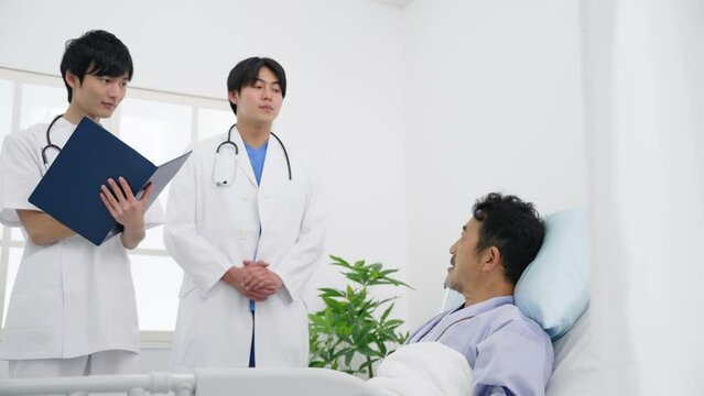 病床で医師と話す入院患者