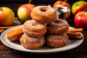Fototapete Bäckerei Glistening with sugary sweetness, apple cider donuts sit stacked on a plate, beckoning to be enjoyed alongside a cool glass of cide