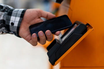 a person makes a purchase using a phone through a terminal, contactless payment