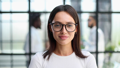 business woman with her staff in background at office