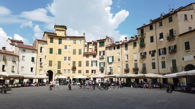 Piazza dell'Anfiteatro square with old yellow houses in Lucca, Italy