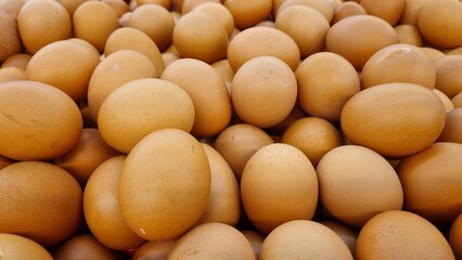Top view of brown chicken eggs in an open egg wooden box. Fresh chicken eggs background. Top view with copy space. Natural healthy food and organic farming concept. Eggs in box.