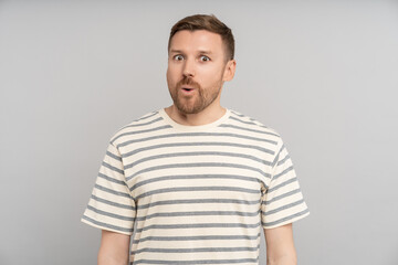 Obraz premium Astonished man looking open mouth in amazement, omg, surprised from ad offer opportunity. Shocked middle aged caucasian male with excited expression round eyes, isolated studio background. Omg, wow