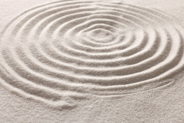 Fototapeta na wymiar Pattern drawn on white sand, closeup. Zen garden