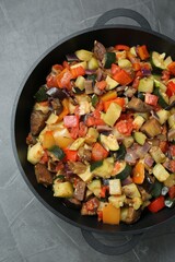 Delicious ratatouille in baking dish on grey table, top view