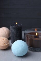 Beautiful composition with aromatic bath bombs on light grey table, closeup. Space for text