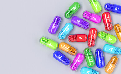 Medical background, vitamin group B, B1, B2, B3, B5, B6, B7, B9, B12, multi-colored capsules, 3d rendering, top view