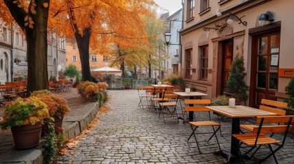Fototapeta na wymiar Cozy autumn cafe terrace with cobblestones and leaves