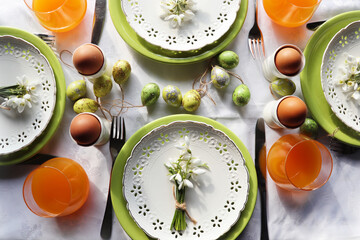 Stylish Easter table setting. Natural egg , snowdrops , modern plate, cutlery. Modern Easter table decoration