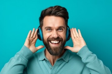 Medium shot portrait photography of a grinning boy in his 30s making a i'm listening gesture with the hand on the ear against a turquoise blue background. With generative AI technology