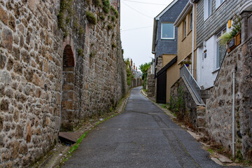 Fototapeta na wymiar Narrow street with traditional stone houses in a coastal town of St Ives, Cornwall, United Kingdom .