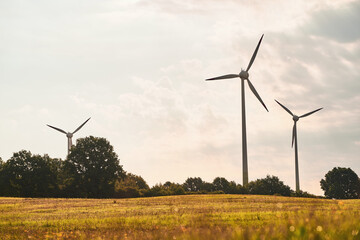 Wind turbines in a wind farm in a beautiful natural environment on a sunny summer day. Renewable energy in Europe