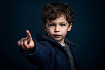 Headshot portrait photography of a tender boy in his 30s pointing with two hands and fingers to the side against a deep indigo background. With generative AI technology