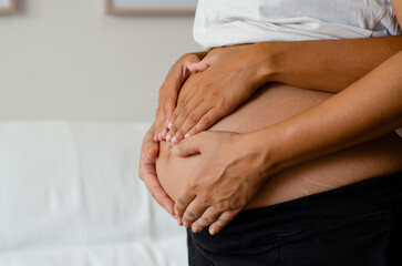 Close up of hands on pregnant woman's belly. Concept of pregnancy and family union . Copy space
