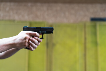 Shooting from a pistol in a shooting range, close-up photo.