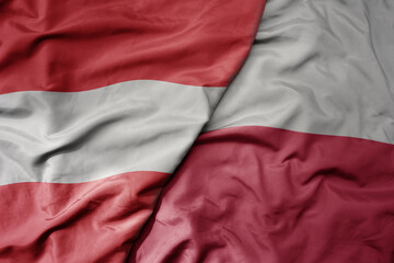 big waving national colorful flag of austria and national flag of poland .