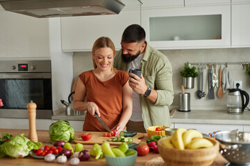 Affectionate couple cutting vegetable in the kitchen
