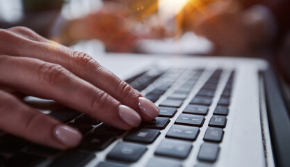 man's hands typing on laptop keyboard in interior