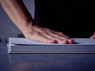 Crop bookmaker making new book in studio