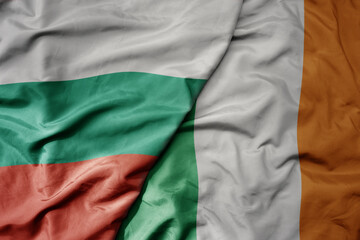 big waving national colorful flag of bulgaria and national flag of ireland .