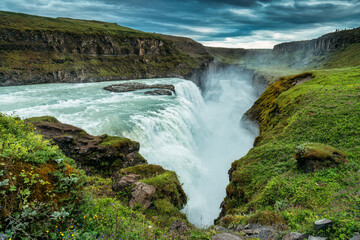 Gullfoss powerful waterfall flowing from Hvita river and moody sky in summer at Iceland