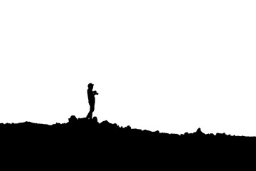 Silhouette of photographer standing with camera taking a photo on the mountain