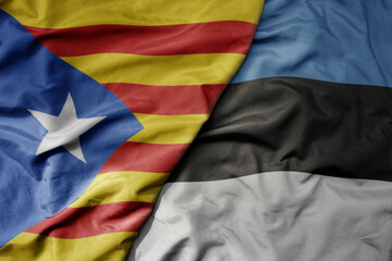 big waving national colorful flag of catalonia and national flag of estonia .