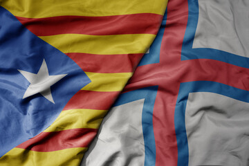 big waving national colorful flag of catalonia and national flag of faroe islands .