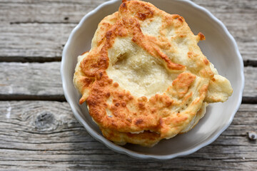 Traditional Bulgarian home made deep fried  patties  covered with sugar  оn rustic backgroud.Mekitsa or Mekica,  on wooden  rustic  background. Made of kneaded dough that is deep fried 