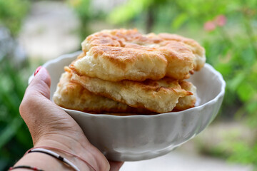 Traditional Bulgarian home made deep fried  patties  covered with sugar  оn rustic backgroud.Mekitsa or Mekica,  on wooden  rustic  background. Made of kneaded dough that is deep fried 