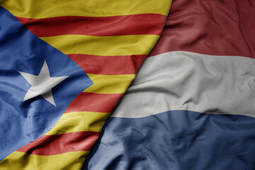 big waving national colorful flag of catalonia and national flag of netherlands .