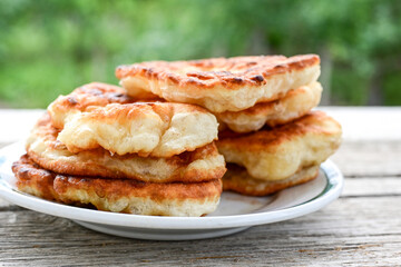 Traditional Bulgarian home made deep fried  patties  covered with sugar  оn rustic backgroud.Mekitsa or Mekica,  on wooden  rustic  background. Made of kneaded dough that is deep fried 