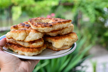 Traditional Bulgarian home made deep fried  patties  covered with sugar  оn rustic backgroud.Mekitsa or Mekica,  on wooden  rustic  background. Made of kneaded dough that is deep fried 