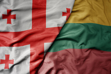 big waving national colorful flag of georgia and national flag of lithuania .