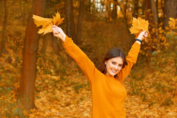 young happy woman love autumn nature and walking outdoors in park with falling leaves