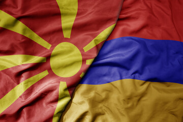 big waving national colorful flag of macedonia and national flag of armenia .