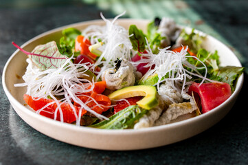 Fresh sashimi salad with salmon fish, tuna and vegetables