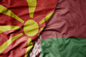 big waving national colorful flag of macedonia and national flag of belarus .