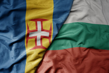 big waving national colorful flag of madeira and national flag of bulgaria .