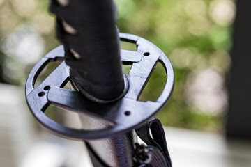 A shallow focus shot of Tsuba, or hand guard, on the handle of a katana (Japanese long sword) It is...