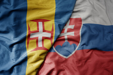 Fototapeta premium big waving national colorful flag of madeira and national flag of slovakia .